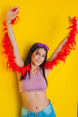 brunette latina woman, raising her hands, celebrating very joyfully with a strip of red feathers on...