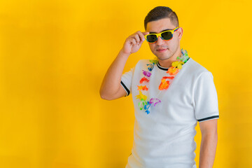 attractive young latin man, grabbing his sunglasses with his hand to take them off. yellow...