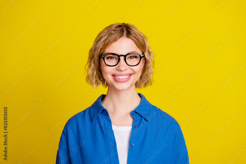 Poster Photo of pretty young girl toothy smile wear blue shirt isolated on yellow color background