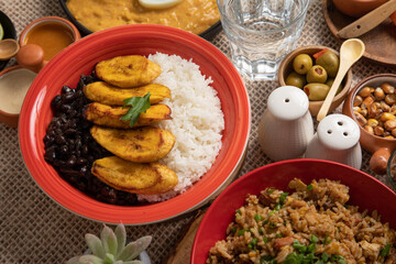 Black beans stew stu with fried plantains banana Buffet table full of lunch assorted dishes Peru...