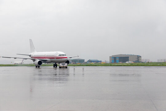 An airplane at the airport on a cloudy day.