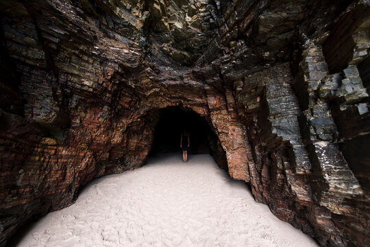 Surreal portrait of woman in dark beach cave