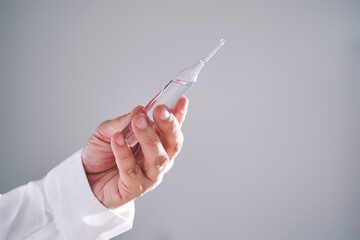 The doctor holds an ampoule with medicine. Close-up.
