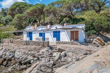 View of white fishermen's cottages. Mediterranean fishermen's cabins on the Costa Brava of Girona, Catalonia, Spain.