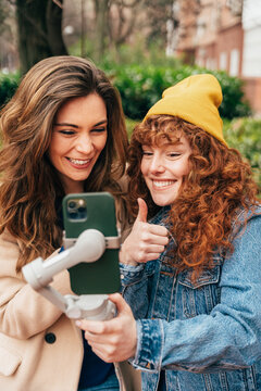 Young women capturing a selfie with a smartphone gimbal