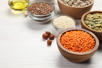 Different products high in vegetable fats on white wooden table, closeup. Space for text