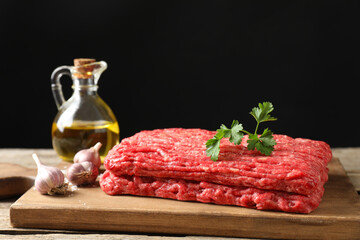 Raw ground meat, garlic, oil and parsley on table