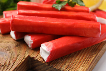 Tasty crab sticks on wooden board, closeup