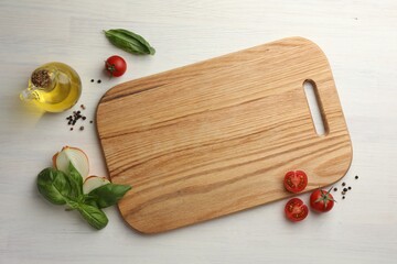 Cutting board, basil, onion, oil and tomatoes on white wooden table, flat lay. Space for text
