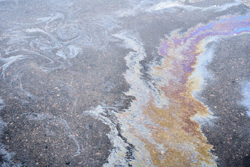 Colored oil stains close-up, color of a gasoline stain on asphalt as a texture or background.