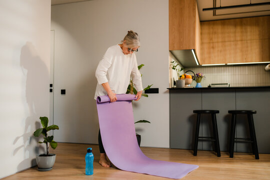 A woman lays out a gymnastic mat