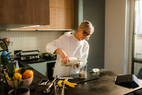 A woman makes smoothies at home