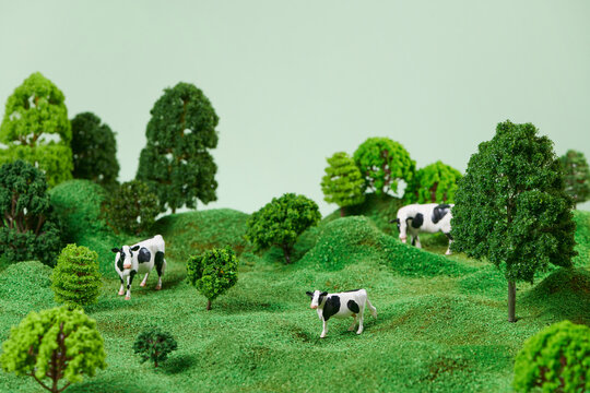 Toy miniature cows view on a meadow