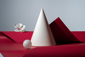 White sphere, cone and flower on red background. Geometric stil life