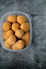 Plastic container with croquettes for frying