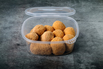 Plastic container with croquettes for frying