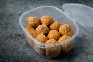 Plastic container with croquettes for frying