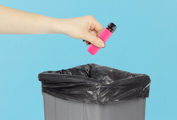 throw the electronic cigarette into the trash, outstretched hand with electronic cigarette in front...
