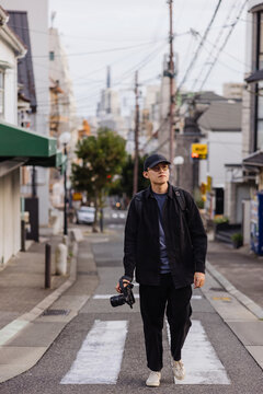 Photographer Walking on Urban Street