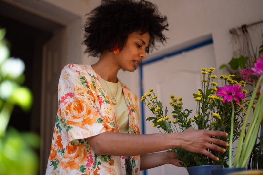 Woman portrait arranging flowers in a vase