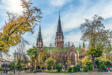 Lviv, Ukraine - November 2, 2023: View from Stepana Bandery Street to the Church of Saints Olha and Elizabeth among golden autumn trees in Lviv. Cityscape with spiers of a Greek Catholic church