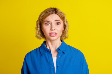 Portrait of pretty young lady worry wear blue shirt isolated on yellow color background