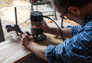 Construction Carpenter blue collar  using router tool with sawdust 