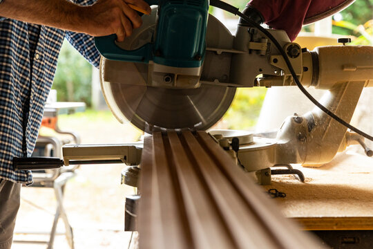 Construction woodworker Carpenter cutting wood with saw 