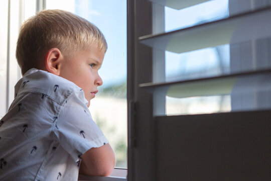 Young boy looking out a window