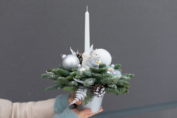Person Holding Christmas Arrangement With Candle