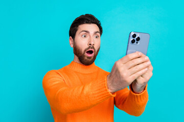 Photo of shocked bearded young man wear orange stylish clothes isolated on cyan color background