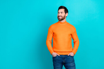 Photo of cheerful young man wear orange stylish clothes look empty space isolated on cyan color...