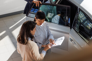 Customer and car salesperson pointing at details of the contract