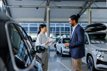 Two car dealership employees having a conversation in the showroom