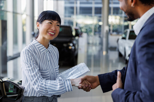 Car salesperson closing sale with handshake