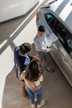 Couple learning about car features from a salesperson
