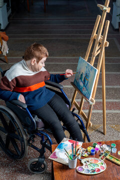 Artist in a wheelchair paints a picture