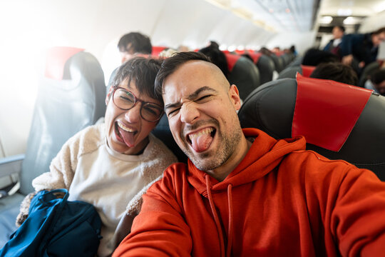 Couple taking selfies on a plane.