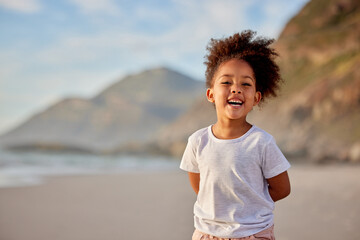 Girl, child and smile with portrait on beach for outdoor fun, travel and tourism on vacation for...