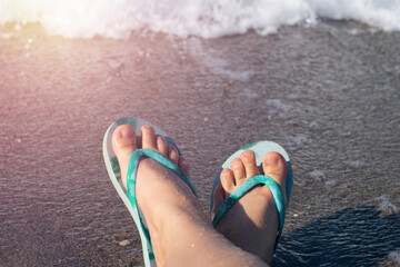 Blue colored summer shoe sandals female woman barefoot on sea shore beach as vacation tourism and...