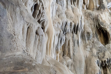Inside view of cave with  a lot of vertical stalactites and stalagmites. Speleology destination