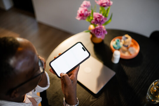 A man uses a mobile phone with white screen