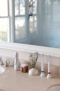 Electric Toothbrush next to sink  still life water flosser mirror