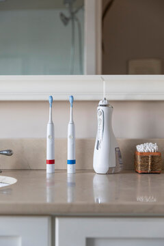 Electric Toothbrush next to sink  still life water flosser countertop