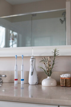 Electric Toothbrush next to sink  still life water flosser interior