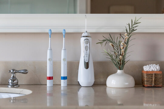 Electric Toothbrush next to sink  still life water flosser 
