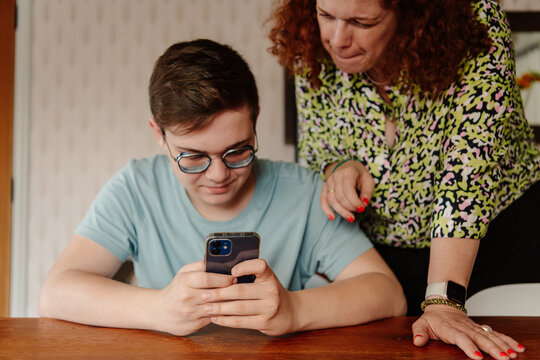 Teenager helping mom with phone 