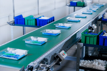 Side view of surgical instrument packs on conveyor, indicating mass preparation for medical use