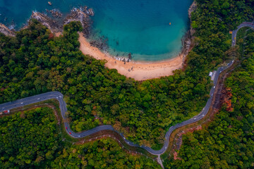 Aerial top view Phuket, sand beach of paradise sea and winding road, sunset time. Concept tropical...