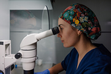 Researcher analyzing samples under microscope